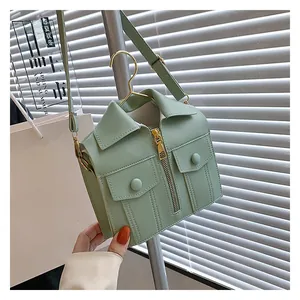 Detail of mint green jacket-shaped crossbody bag featuring collar and zipper accents