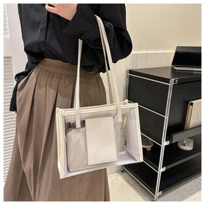 Detailed close-up of transparent PVC jelly tote bag with white faux leather inner pouch