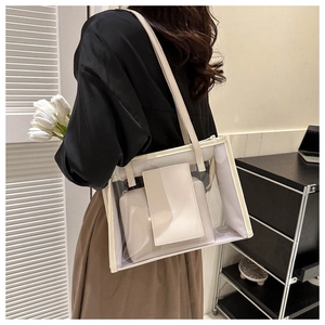 Close-up of a clear PVC tote bag with cream leather trim and a matching inner pouch