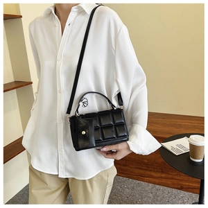 Detail of black quilted crossbody bag with matching detachable mini coin purse