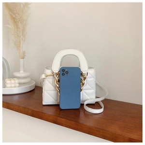 White quilted handbag with gold chain detail and phone for size reference