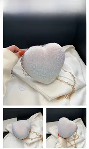 Detail of white heart-shaped hardshell clutch with iridescent sequins and gold chain strap
