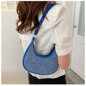 Detail of royal blue crescent hobo bag featuring silver rivets and adjustable strap