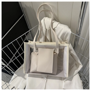 Detail of transparent PVC tote bag with cream leather trim and matching inner pouch