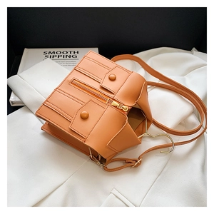 Close-up of orange crossbody bag with jacket-style zipper and pocket details