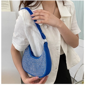 On-body view of a royal blue hobo bag featuring sparkling silver rhinestone embellishments