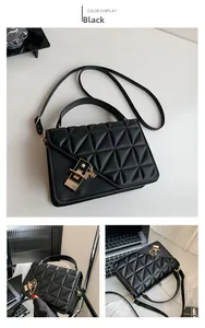 Detail view of black quilted crossbody bag with gold hardware and triangular stitching