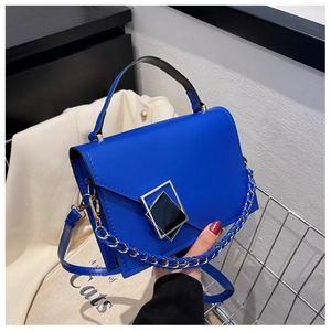 Close-up of bright blue fashion handbag with geometric metal buckle and chain strap