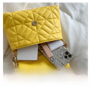 Internal capacity of yellow quilted PU leather bag with items and gold chain strap