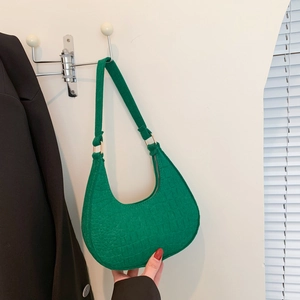 Borsa hobo verde con motivo a coccodrillo e anelli dorati in un ambiente di stile di vita