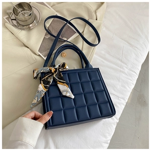Détail du sac à main matelassé bleu foncé avec foulard en soie rétro sur les poignées