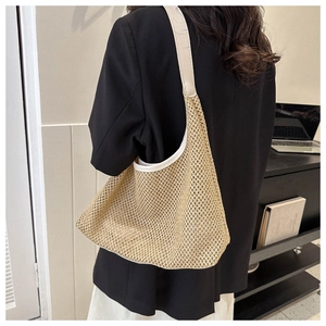 Detail of hand-woven straw tote bag with cream leather strap for beach or office