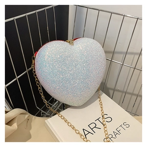 Detailed macro view of heart-shaped glitter bag with a chic golden metal chain strap