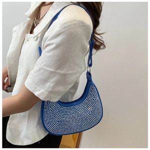 Detailed view of shiny blue rhinestone underarm bag with silver chain and metal rings