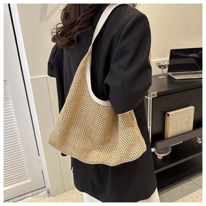 Detail view of woven shoulder bag with white leather trim styled with casual blazer