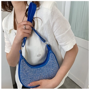 Detailed close-up of blue crescent bag with sparkling silver rhinestones and wide strap