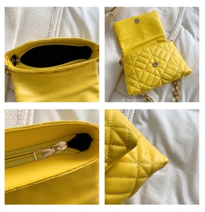 Detail view of yellow quilted PU leather bag featuring acrylic chain and inner zipper pocket