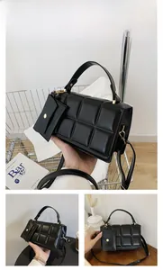 Detail view of black woven square handbag with matching mini pouch and gold hardware