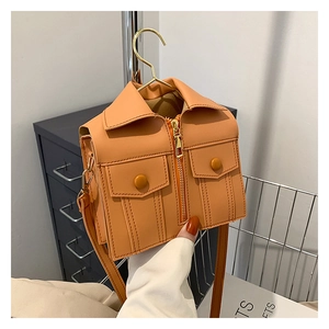 Creative jacket-shaped orange shoulder bag with collar and pocket details on a hanger