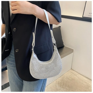 Detail of silver rhinestone hobo bag showing sparkling crystals and adjustable white strap