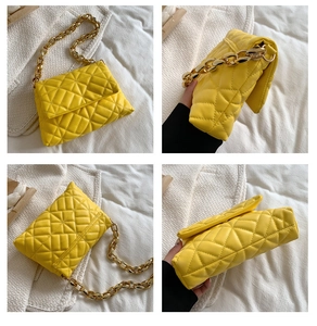Detail view of bright yellow quilted shoulder bag with chunky gold chain strap