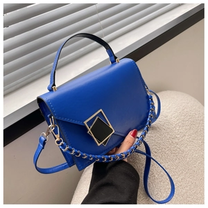 Detail of Klein blue square PU leather handbag with gold geometric buckle and chain