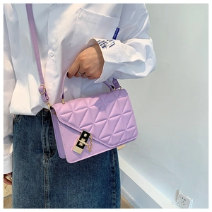 Detail of purple quilted crossbody bag featuring gold hardware and elegant chain strap