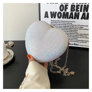Detailed close-up of glittering heart-shaped crossbody bag with gold chain strap