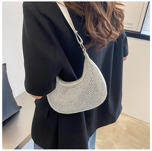 Detail of silver rhinestone half-moon bag with sparkling crystals on shoulder