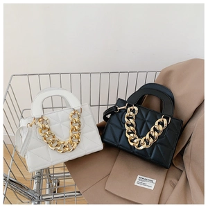 Close-up of quilted leather handbags with thick gold chain straps in a shopping basket