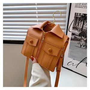 Detail of creative orange jacket-shaped crossbody bag with metal hanger hook and PU texture