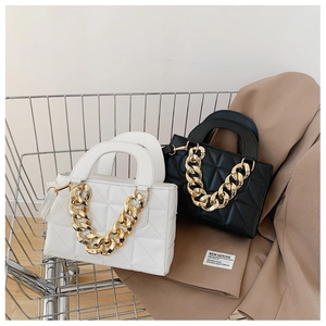 Detail of quilted leather bags with chunky gold chain handles on a shopping cart