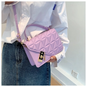 Detail of lavender quilted cross-body bag featuring gold lock and adjustable strap