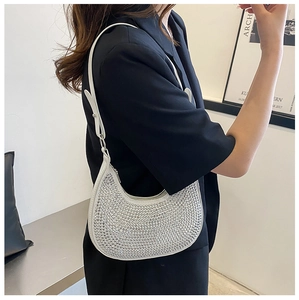 Detail shot of a silver rhinestone underarm bag with sparkling crystal finish and strap