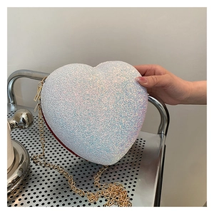 Detail of heart-shaped glitter evening bag featuring white sequins and red trim