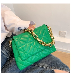 Close-up of bright green quilted PU leather handbag with chunky gold acrylic chain detail