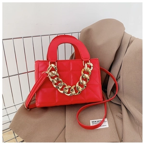 Close-up of red quilted PU leather handbag featuring thick gold metal chain and strap