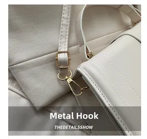 Macro shot of light gold metal hook and adjustable beige leather strap detail