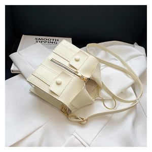 Detail of creative beige jacket-shaped bag with gold zipper on white suit background