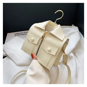 Close-up of cream faux leather jacket-shaped crossbody bag with gold hanger handle