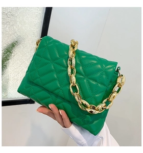 Detail of green quilted cloud bag featuring golden thick chain strap and soft PU texture