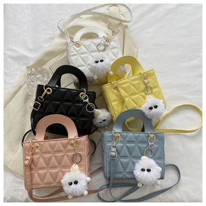 Detailed view of colorful quilted mini handbags with cute plush monster charms and straps