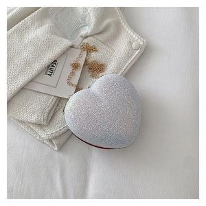 Close-up of heart-shaped glitter evening bag with colorful sequins and golden chain