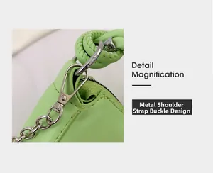 Close-up of green leather bag featuring silver metal D-ring and chain strap buckle