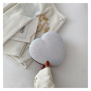 Detailed view of heart-shaped glitter bag with golden chain and pearl texture finish