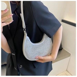 Detail of silver rhinestone underarm bag showing sparkling texture on a shoulder strap