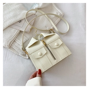 Detailed view of cream jacket-shaped crossbody bag with mini hanger handle and zip