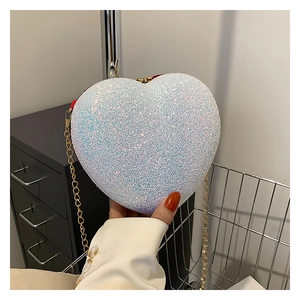 Close-up of heart-shaped handbag featuring purple glitter surface and red zipper detail