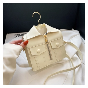 Detail of creative cream white jacket-shaped crossbody bag with gold zipper and collar design
