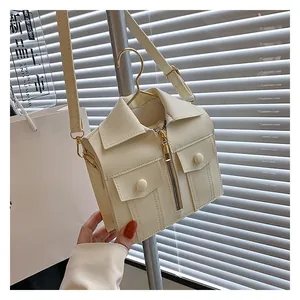 Detail of creative jacket-shaped crossbody bag hanging on a metal hanger